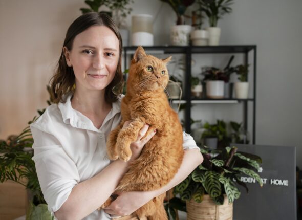 woman-growing-plants-home-holding-cat